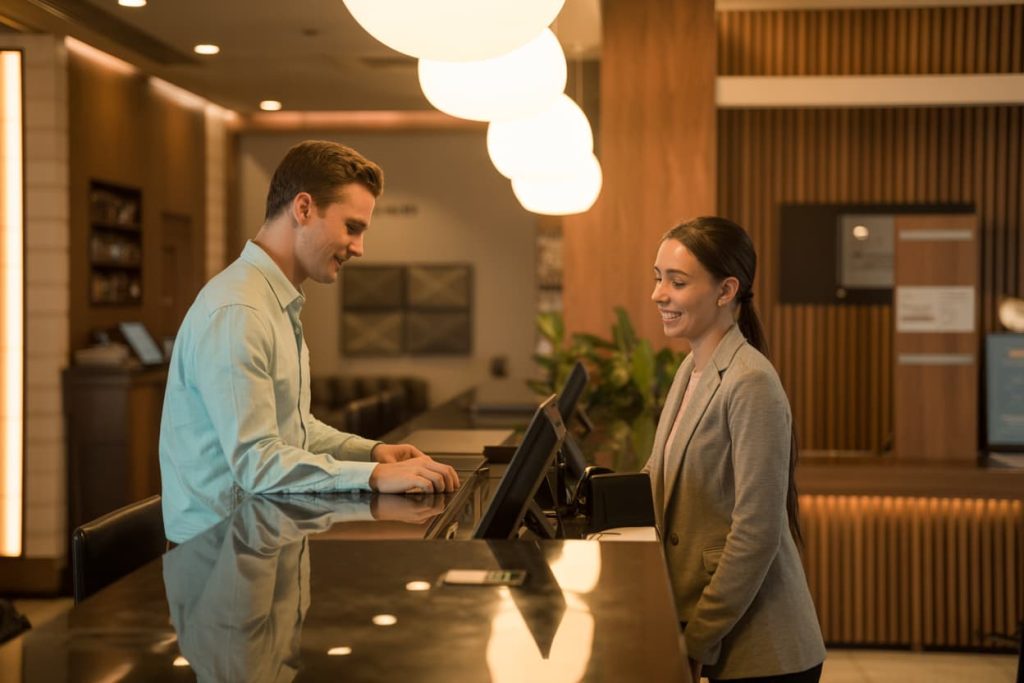 Traveler checking in at hotel front desk, calm lobby, warm indoor lighting”